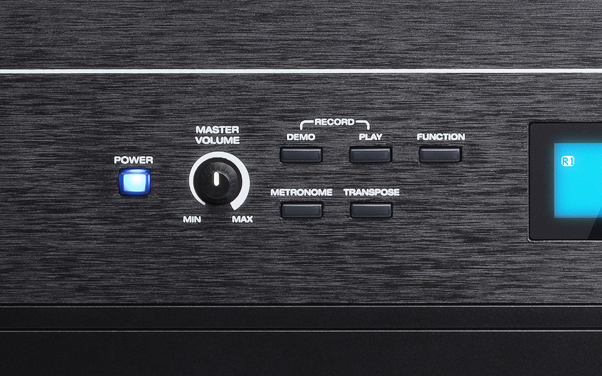 Крупный план панели Alesis Recital Pro: кнопки Record, Demo, Play, Function, Metronome, Transpose, ручка громкости и голубой LCD-дисплей