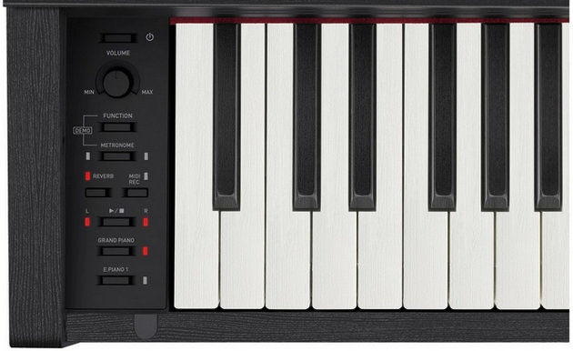 Левая часть чёрного корпуса цифрового пианино Casio PX-770: ручка громкости VOLUME со шкалой MIN—MAX, ниже кнопки FUNCTION, METRONOME, REVERB, MIDI REC, кнопки транспорта записи и тембры GRAND PIANO и E.PIANO 1, справа начинается клавиатура