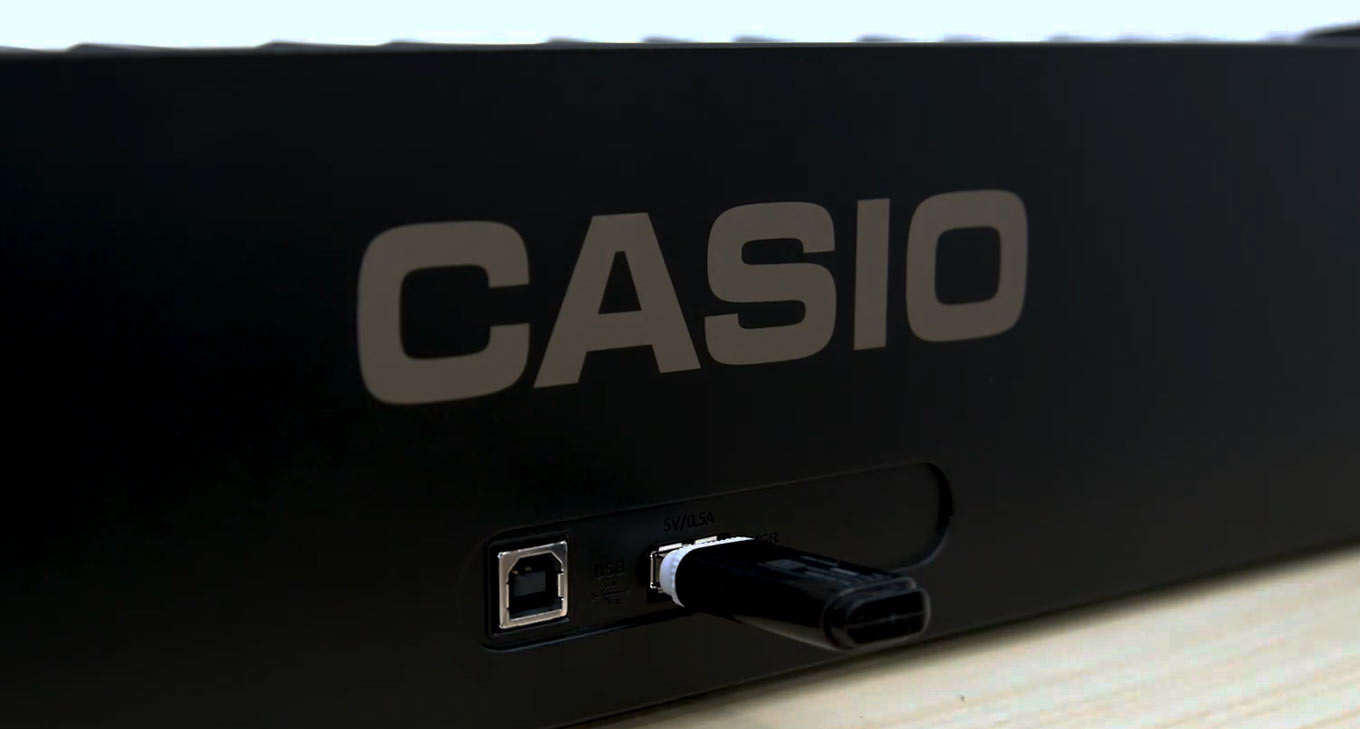 Торец цифрового пианино Casio PX-S3100: слева квадратный порт USB тип B, справа плоский порт USB тип A с воткнутой флешкой