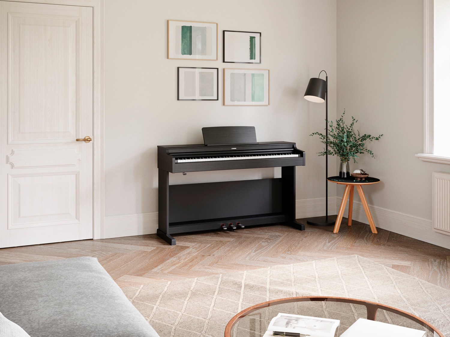 Чёрное консольное цифровое пианино Yamaha YDP-165 Arius у стены светлой комнаты: тумба с тремя педалями, поднятый пюпитр, рядом торшер и столик с зеленью