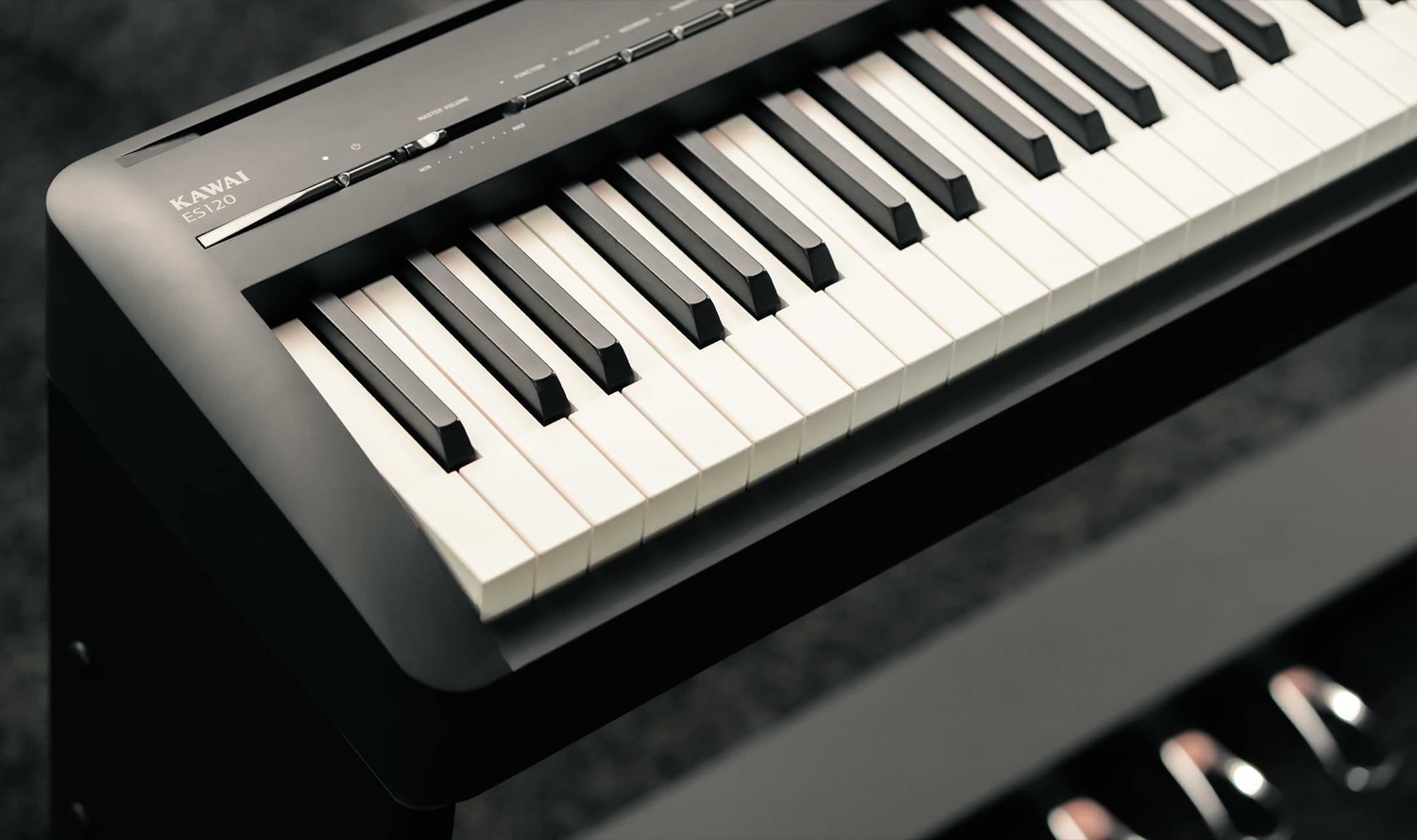 Левая часть панели Kawai ES120 крупным планом: логотип KAWAI ES120, слайдер MASTER VOLUME со шкалой MIN–MAX, ряд плоских кнопок с подписями FUNCTION, PLAY/STOP и матовые клавиши рядом