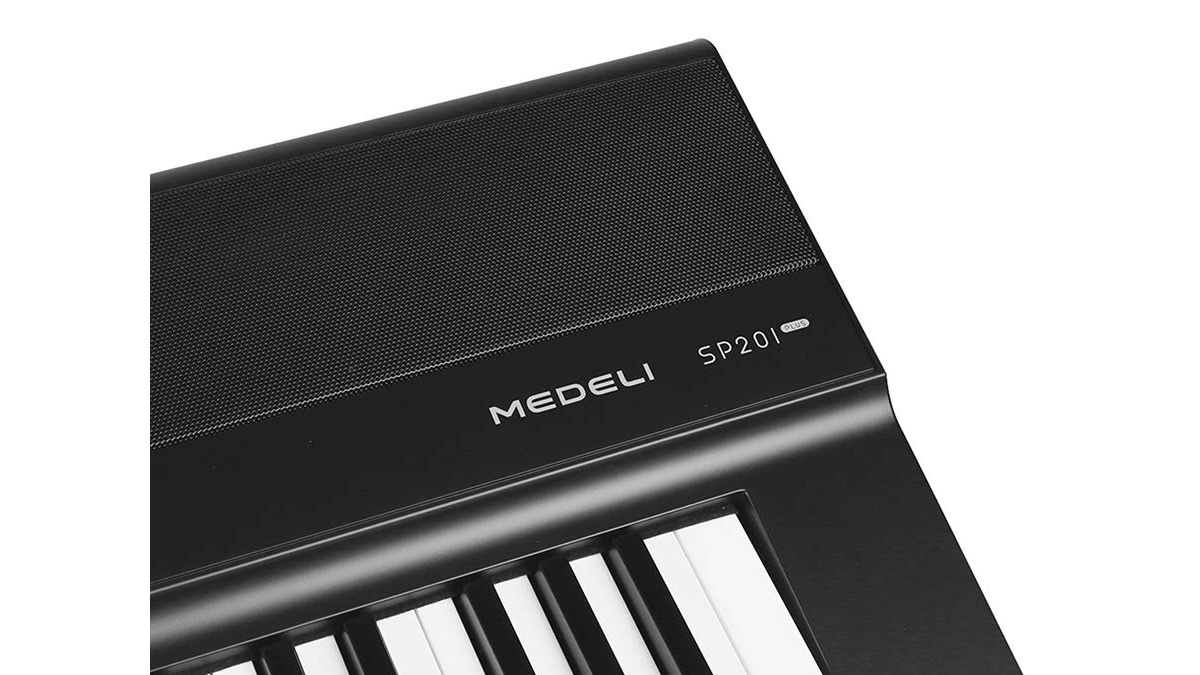 Крупный план цифрового пианино Medeli SP201+: фирменный шильдик MEDELI над клавишами и решётка динамика