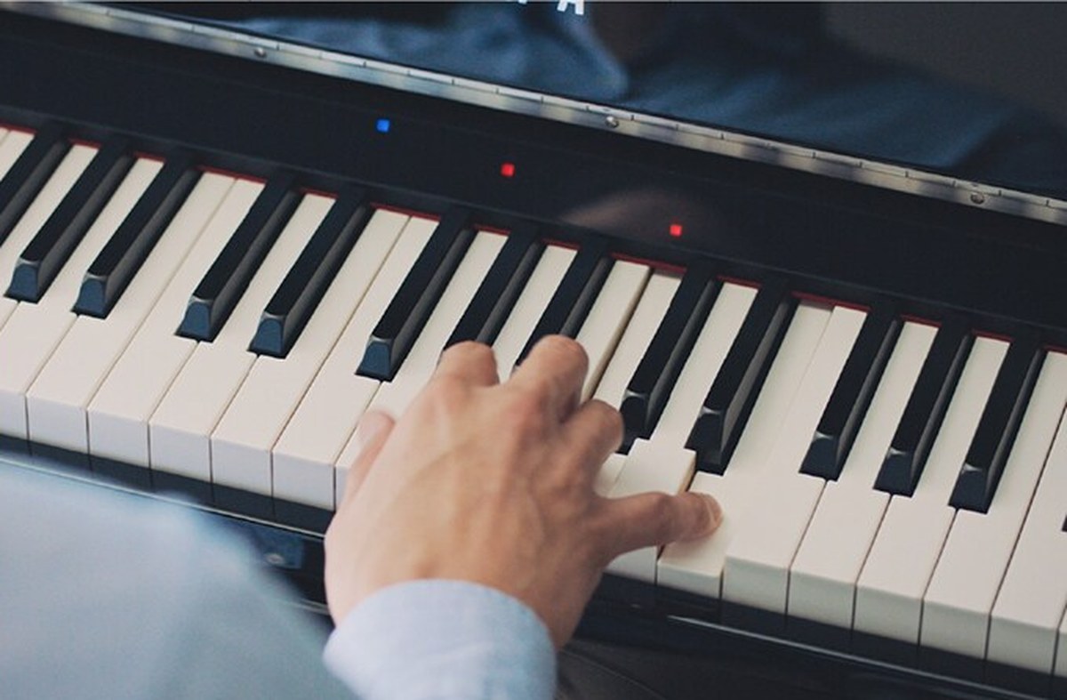 Клавиатура Yamaha CSP крупным планом: над клавишами горят один синий и два красных светодиода Stream Lights, правая рука берёт аккорд