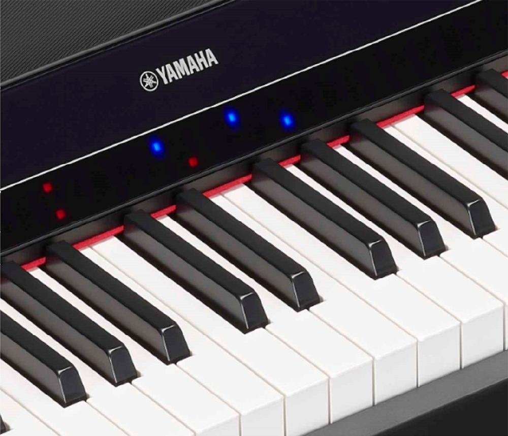 Крупный план клавиатуры Yamaha P-S500: в чёрной панели над клавишами горят красные и синие точки подсказки